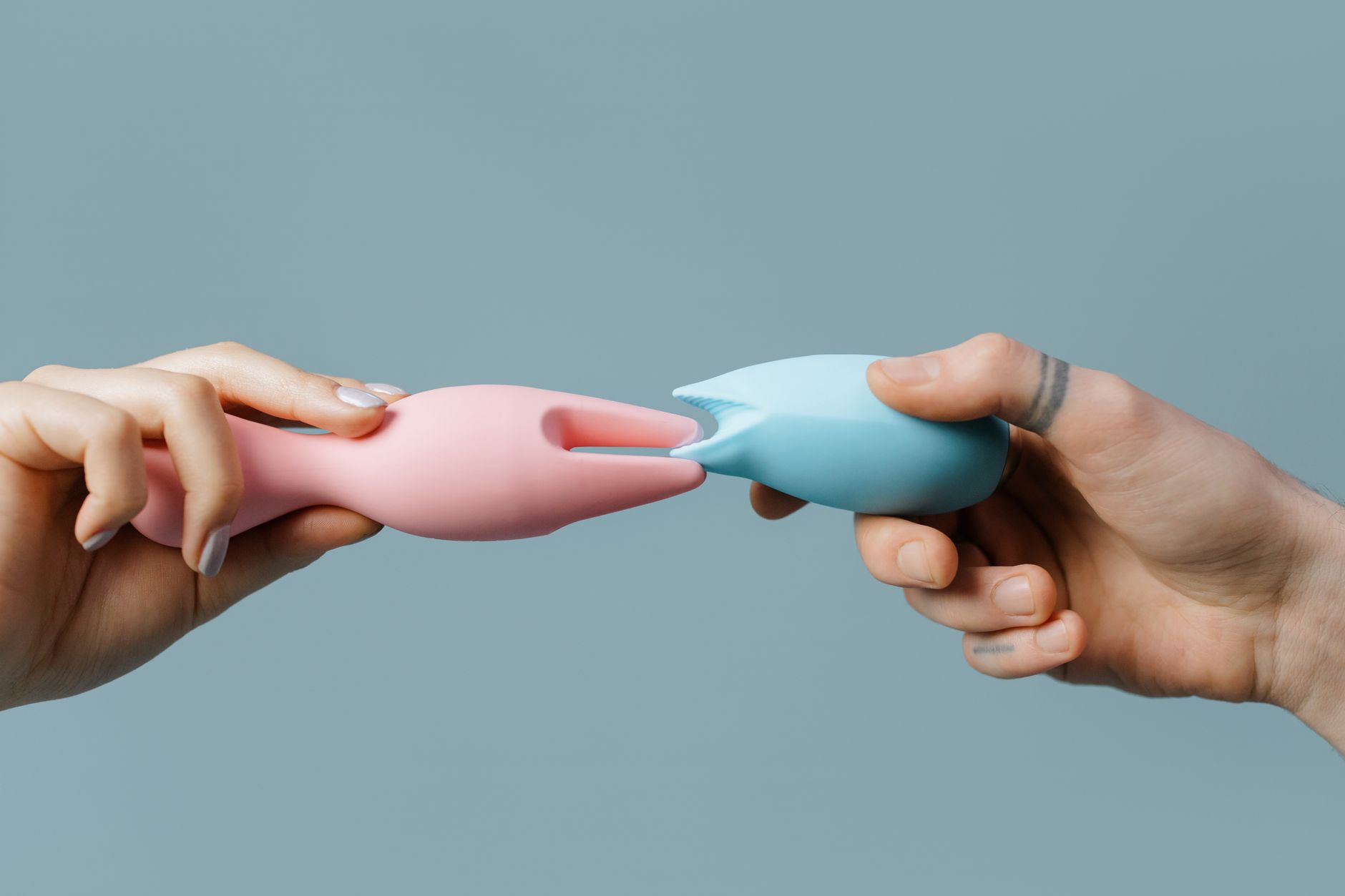 A hand reaching over a variety of colorful clitoral vibrators, representing options for new partners