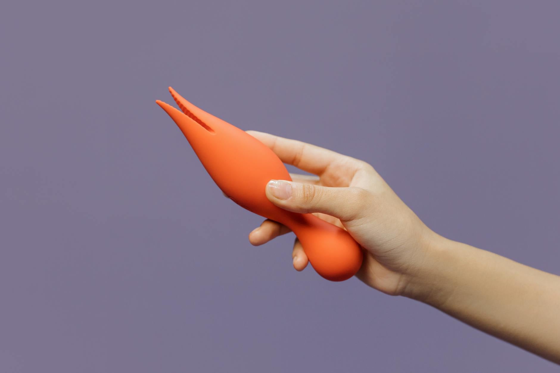 Mão segurando um vibrador de limão contra fundo minimalista, representando intimidade e sensualidade moderna