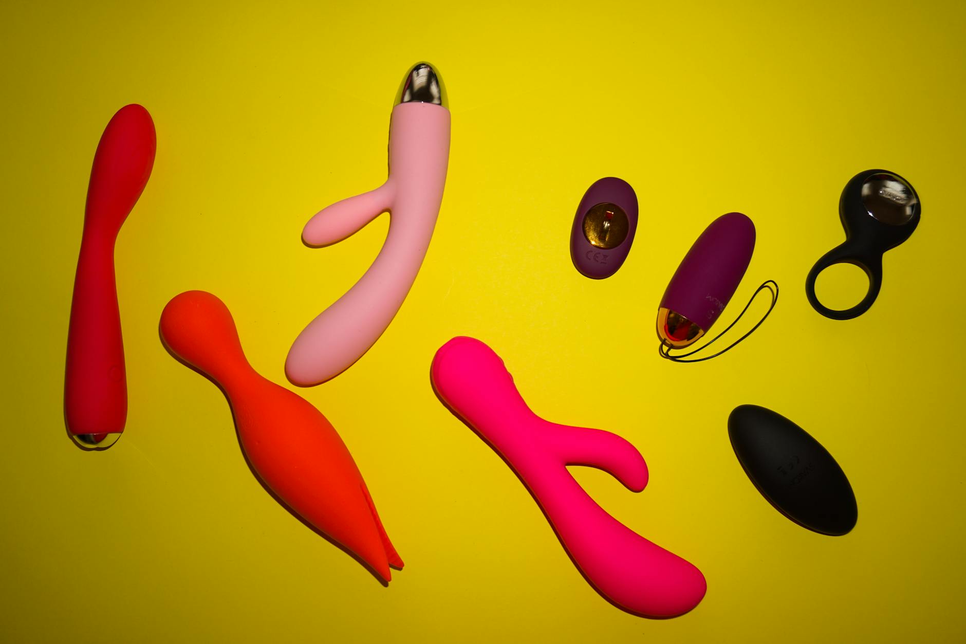 Mãos segurando um vibrador azul em close contra fundo roxo